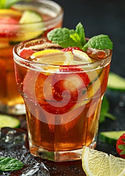 Refreshing Pimms Cocktail with Fruit and vegetables on rustic black table