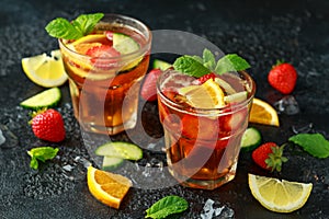 Refreshing Pimms Cocktail with Fruit and vegetables on rustic black table