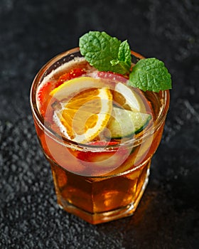 Refreshing Pimms Cocktail with Fruit and vegetables on rustic black table