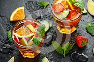 Refreshing Pimms Cocktail with Fruit and vegetables on rustic black table