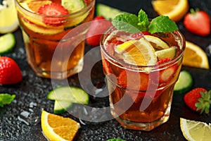 Refreshing Pimms Cocktail with Fruit and vegetables on rustic black table