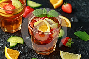 Refreshing Pimms Cocktail with Fruit and vegetables on rustic black table
