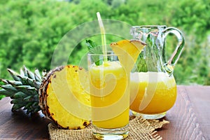 Refreshing pineapple mocktail drink in glass and pitcher