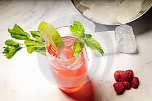 Refreshing raspberry cocktail with crushed ice, mint and lime