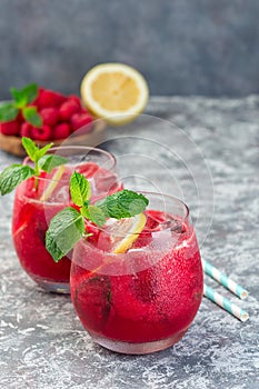 Refreshing raspberry, lemon and mint lemonade with sparkling water in  glass, vertical, copy space