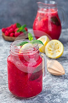 Refreshing raspberry, lemon and mint lemonade with sparkling water in  jar, vertical