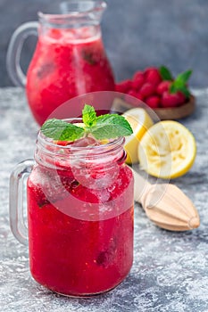 Refreshing raspberry, lemon and mint lemonade with sparkling water in  jar, vertical