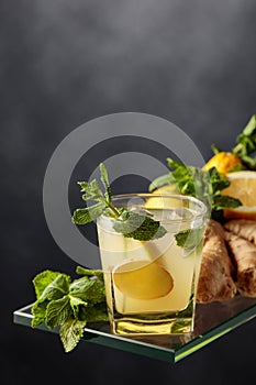 Refreshing summer cocktail with ice, ginger, lemon, and mint
