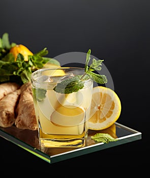 Refreshing summer cocktail with ice, ginger, lemon, and mint