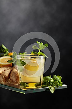 Refreshing summer cocktail with ice, ginger, lemon, and mint