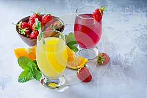 Refreshing summer drinks assortment. Orange juice, strawberry juice, fresh oranges and strawberries