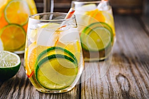 A refreshing summer ice-cold drink. White wine sangria in glass with lime, lemon and orange