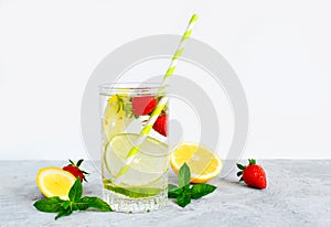 Refreshing summer lemonade in a glass cup from lemon, lime, strawberry, orange, mint on a white background. Flax drinks