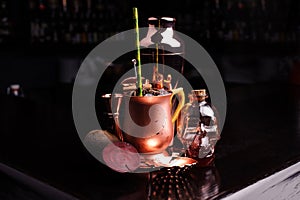 Refreshing summer punch and copper bar tools on dark background