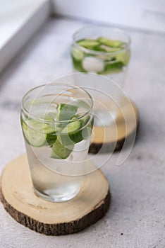 Refreshing water with cucumber on a coaster