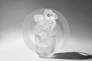 Refreshing water with ice in glass on grey background