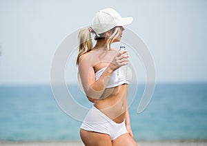 Refreshing after workout. Beautiful young blonde woman in sports clothing drinking water