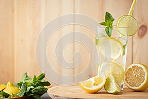 refreshment drink mojito with mint, lemon and lime in a glass on a rustic wooden background