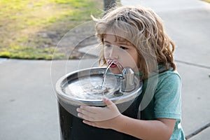 Refreshment solution. Thirsty kid drink water from drinking fountain. Thirst quenching