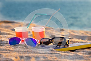 Refreshments, sun glasses and a book for a relaxing day on the beach