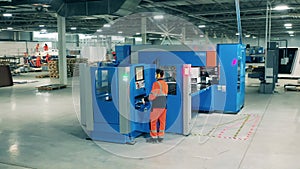 Refrigeration factory worker is controlling an industrial machine