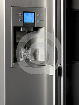 Refrigerator control display and ice dispenser with glass