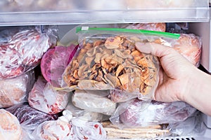 Refrigerator with frozen food. Frozen dried fruits in a package. Open fridge freezer