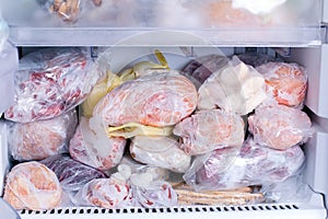 Refrigerator with frozen food. Open fridge freezer meat, milk, vegetables.