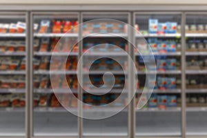 Refrigerators with chilled fish products in packages in a supermarket. Front view. Blurred