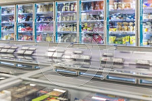 Refrigerators with chilled products in the supermarket. Semi-finished products and freezing. Blurred