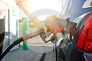 Refuel the car. a woman at a gas station on a sunny summer day refuels the car