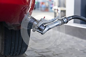 refuel the red car at the gas station during the day.