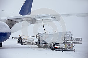 Refueling of airplane on frosty winter day at airport