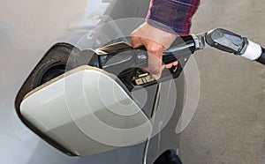 Refueling the car at a gas station fuel pump. Man driver hand refilling and pumping gasoline oil the car with fuel