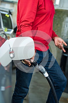 Refueling the car at a gas station fuel pump. Man driver hand refilling and pumping gasoline oil the car with fuel