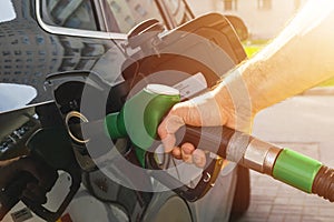 Refueling the car at a gas station fuel pump. Man driver hand refilling and pumping gasoline oil the car with fuel at he refuel st