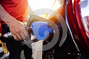 Refueling the car at a gas station fuel pump. Man driver hand refilling and pumping gasoline oil the car with fuel at he refuel st