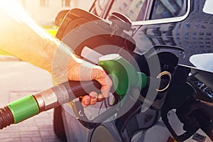 Refuelling the car at a gas station fuel pump. Man driver hand refilling and pumping gasoline oil the car with fuel at he refuel s photo