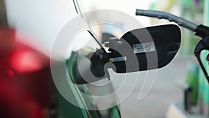 Refueling a car at a gas station. Hand holding and recording the process. Fuel, gas station, petrol prices concept