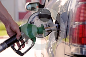 Refueling a car at a gas station. The man is going to start filling the car with gasoline at the gas station.