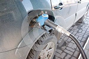 refueling a dark green jeep at a gas station, the pestolet is inserted into the tank. gasoline price rise concept.
