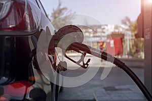 Refueling a petroleum vehicle at gas station in warm sunset