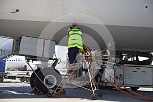 Refueling the plane at the airport. Male worker on the stairs. Close-up, place for text