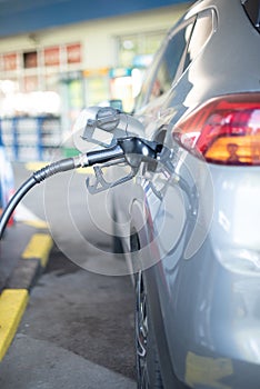 Refueling refilling car vehicle with fuel at refuel fuel gas pump station - Petrol diesel gas pump gun in the tank to fill -