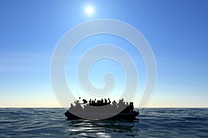 Refugees on a big rubber boat in the middle of the sea that require help