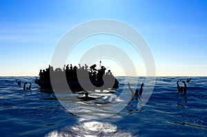 Refugees on a big rubber boat in the middle of the sea that require help