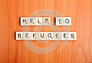 Refugees help text wooden tiles letters