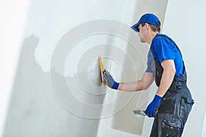 refurbishment. Plasterer worker spackling a wall with putty