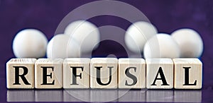 REFUSAL - word on wooden cubes on a blue background with wooden balls