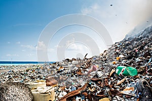 Refuse at the garbage dump full of smoke, litter, plastic bottles,rubbish and trash at tropical island